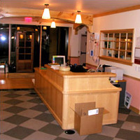 A side view of a large check-in desk with window into the class space beyond in the entrance of a child development center